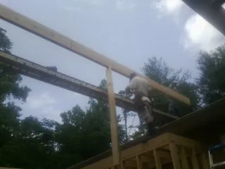 Carpenter setting a ridge beam over a new addition frame — Ice Dam Removal by Roofing Brothers in Porter